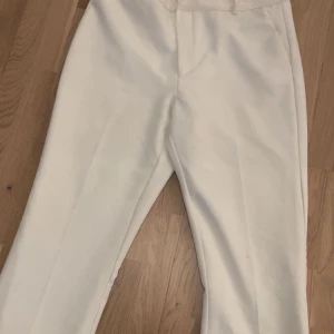 Vita bootcut  kostymbyxor  - Snygga vita kostymbyxor med normal passform och boot cut mid waist 
