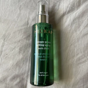 Hickap  Setting Spray - Grön flaska med genomskinlig pump, innehåller en mattande setting spray som är 100% vegansk och passar alla hudtyper. Perfekt för att fixera sminket och ge en fräsch finish. Innehåller 100 ml. Oanvänd