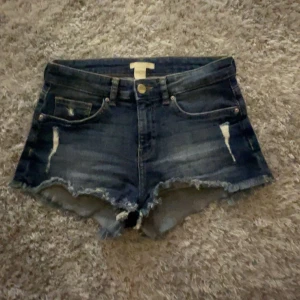 Mörkblå jeansshorts med slitningar - Säljer dessa super snygga mörkblå jeansshorts med råa kanter och slitna detaljer framtill. 💓Dem är så bekväma och perfekta nu till sommaren! Skriv till mig för fler frågor och köp nu, jag postar snabbt!💞💞
