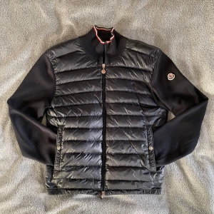 Moncler Cardigan - Säljer denna otroligt snygga Moncler cardiganen i en sällsynt model! 🙌 Storlek = M | Skick 8/10 | Nypris över 11 000kr, mitt pris = 2249kr! 🙌 Den har ett pyttelitet hål på högra bröstet, men absolut inget som syns när den bärs! ⭐️Självklart äkta! Hör av er vid minsta fråga eller fundering! 🤝