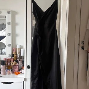Svart satin långklänning  - Säljer min gamla bal klänning med en gansk hög slits och en v ringning. (Andvänd 2 gånger)