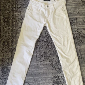 Vita Replay Anbass jeans, stl 29 - Snygga vita jeans från Replay, modell Anbass. Klassisk femficksdesign, raka ben och normal passform. Tillverkade i bomull 
