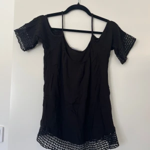 Svart blus med virkade detaljer - Svart blus med tunna axelband och virkade detaljer.