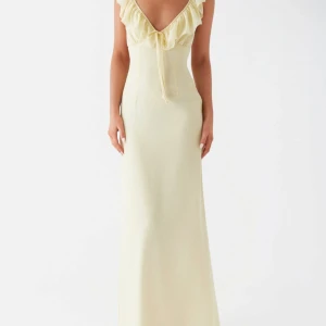 Ljusgul långklänning från Peppermayo - Superfin ljusgul långklänning från Peppermayo med volangdetaljer vid v-ringad urringning och knytband framtill. Klänningen har öppen rygg med knyt och är ärmlös. Perfekt för sommarens alla tillfällen! Säljer då den var lite för tajt och inte heller gick att returerna, aldrig använd!! Nypris 900kr