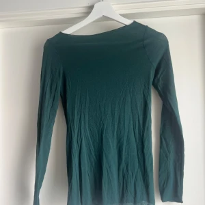 Mörkgrön långärmad tröja Intimissimi - Mörkgrön långärmad tröja från Intimissimi i tunn och mjuk ull- och kashmirblandning. Enkel och stilren modell med rund halsringning och smal passform, perfekt att styla lager på lager eller som den är.
