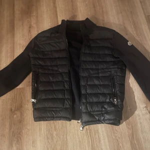 Svart quiltad pufferjacka från Moncler - Säljer en svart pufferjacka från Moncler med quiltad front och släta ärmar. Skick 6 av 10 då lite solbränt 