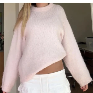 Ljusrosa stickad croppad tröja - Supermjuk och fluffig ljusrosa stickad tröja med croppad passform. Tröjan har rund halsringning och långa ärmar, perfekt för att skapa en söt och avslappnad look. Passar perfekt till både jeans och kjol. Superfint skick!🌸🌸