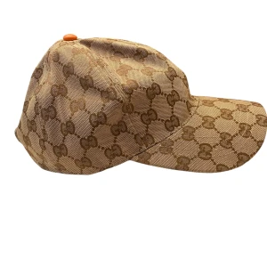  beige keps - Exklusiv keps i beige med brunt . Klassisk böjd skärm och justerbar passform. Tillverkad i slitstark canvas med lyxig känsla och ikonisk design.