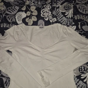 Vit topp! - En simpel och fin långärmad topp! Toppen är från Bubbleroom. Den har en lite kantig urringning som även är rynkad vilket är väldigt fint! Köpt på Sellpy men har själv knappt använt den, fint skick! Inga defekter jag kan hitta utom ett pyttehål under ena armhålan och lappen är sliten. Djur finns i hemmet! ❤️😇