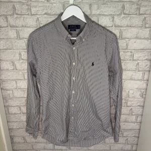 Ralph Lauren skjorta - Randig skjorta ifrån Ralph Lauren i mycket fint skick. Använd enstaka gång och säljes nu till ett bra pris. Hör av dig vid intresse! 🙌