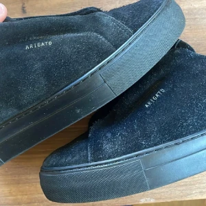 Svarta sneakers i mocka från Axel Arigato - Snygga svarta sneakers från Axel Arigato i mjuk mocka.