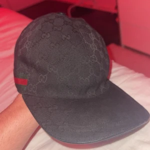 Svart Gucci keps  - Säljer en svart Gucci keps knappt andvänd den har bara stått i min garderob.  Perfekt för dig som vill ha en lyxig och stilren accessoar. Öppen till byten kan gå ner vid snabb affär