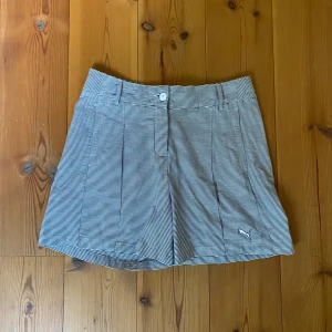 Randiga shorts från Puma - Snygga randiga minishorts från Puma i blått och vitt med broderad logga. Perfekt skick förutom en liten fläck/prick bredvid loggan (se sista bild), men går säkert att få bort med tabortspray.