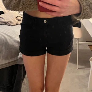 Svarta jeansshorts - Svarta jeansshorts med medelhög midja. De har knapp och dragkedja framtill och är i mycket bra skick. Storlek XS.