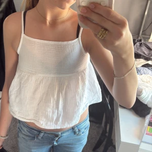 As gullig vit topp! - Superfin vit linnetopp från Gina Tricot med tunna axelband, lös passform runt magen. Säljer på grund av att den varit för liten sen jag fick den så inte använt 
