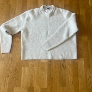 Ljusbeige stickad tröja från Bershka - Stickad tröja från Bershka – helt ny med tag  Beige stickad tröja från Bershka i storlek M. Helt ny och aldrig använd, lappen sitter fortfarande kvar. Mjuk och skön i materialet, perfekt både till vardags och om du vill klä upp dig lite men ändå vara bekväm.  Normal passform med rund halsringning och diskret struktur i tyget. Färgen är lätt att matcha med allt.  Säljer för att den inte kommer till användning.  Hör av dig om du har frågor! 