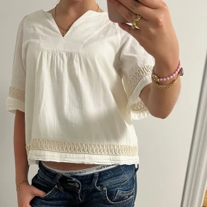 Vit blus med broderad kant - Jätte snygg vit/beige blus. Jätte skön i materialet! Perfekt nu till sommaren 