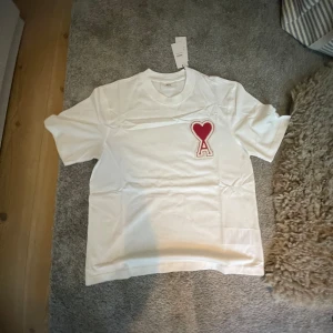 Vit t-shirt från från Ami Paris - Säljer en  vit t-shirt från Ami Paris . Storlek xs men passar s. Helt ny oanvänd