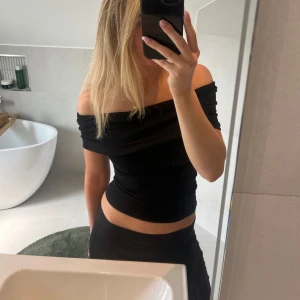 Svart offshoulder topp från Zara - Säljer en svart offshoulder topp från Zara. Toppen har en stretchig passform och man kan ha den på flera olika sätt (som jag visar på de två första bilderna). Endast använd 1 gång och är som ny! Storlek M men passar även S, jag är 175 cm som referens. 💗💗💗