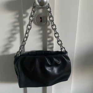Svart handväska med kedja - Svart handväska med ett grovt silverfärgat kedjehandtag. 