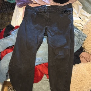 Svarta jeansbyxor med raka ben - Svarta jeansbyxor med klassisk femficksdesign och raka ben. Byxorna har normal passform och är tillverkade i ett mjukt denimtyg. Perfekta för dig som gillar en enkel och stilren look.