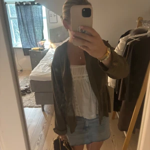 Olivgrön kavaj från H&M - Säljer en olivgrön kavaj från zara med klassisk krage och knappar framtill. Jackan har lång ärm och är i ett tunt, mjukt material som passar perfekt till lager-på-lager. Enkel och stilren modell.