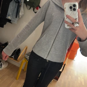 Grå hoodie med dragkedja från Polo Ralph Lauren - Säljer en grå hoodie från Polo Ralph Lauren med dragkedja framtill och huva. Tröjan har två fickor på magen och den klassiska broderade loggan på bröstet. Köptes second hand för något år sedan!💕Loggan ” har ingen färg” utan är synlig vid visst ljus. Tveka inte om att fråga!!