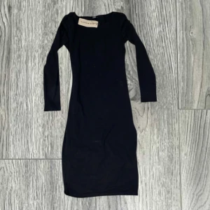 Svart långärmad klänning från SHEIN - En svart, figurnära klänning från SHEIN med lång ärm och rund halsringning. Klänningen är enkel och stilren, perfekt för dig som gillar minimalistisk stil. Ny med prislapp.  (1) 
