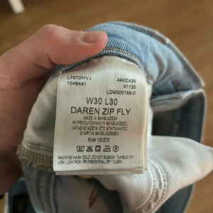 Ljusblå jeans från Lee - Säljer ett par ljusblå jeans från Lee med klassisk femficksdesign och Lee-logga på bakfickan. Jeansen har en rak passform och är perfekta för en avslappnad stil.