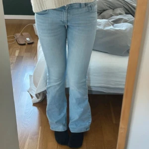 Ljusblå bootcut jeans med dubbla knappar - Säljer ett par ljusblå jeans med bootcut-modell och dubbla knappar i midjan. Bara använda ett fåtal gånger! Storlek 170                        Midjemåttet: 37 cm, innerbensmåttet: 80 cm