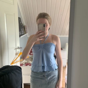 Ljusblå halterneck topp med volang - Jätte söt sommar topp i en jätte fin blå färg. Knytning bak i nacken så det blir som en halv öppen rygg. Aldrig använd. Skriv för fler bilder och pris kan diskuteras vid snabb affär.