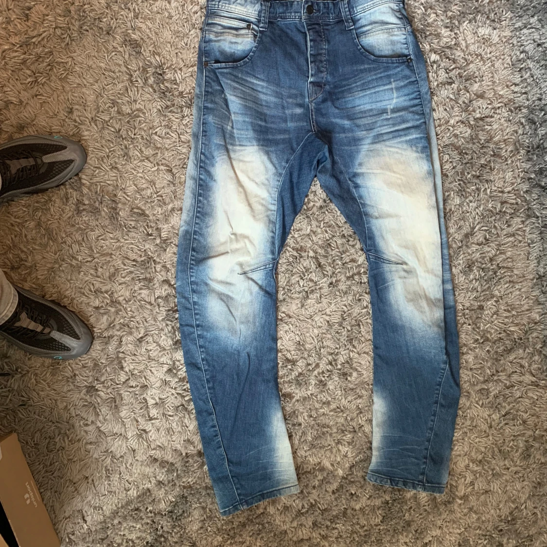 Blå jeans med slitningar