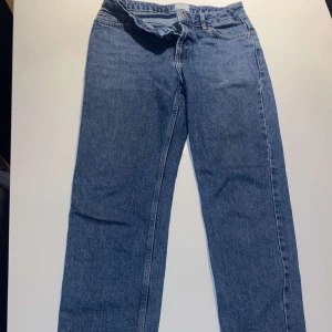 Blå jeansbyxor från Grunt - Säljer ett par klassiska blå jeansbyxor från Grunt i ekologisk bomull. Byxorna har normal passform, raka ben och traditionell femficksdesign. Perfekta för dig som gillar en enkel och tidlös stil.