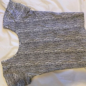 Svartvit mönstrad linnetopp - Säljer en svartvit ärmlös linnetopp med abstrakt mönster. Toppen har rund halsringning och är öppen i ryggen (fläck på den som jag visar på bilden har inte testat något för att få bort)💗dock så ser man inte fläcken om man har på sig toppen 