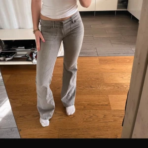 Grå bootcut jeans ifrån Nelly  - Säljer ett par gråa bootcut jeans med låg midja och klassiska fickor bak och fram. Jeansen har en snygg, enkel design och är perfekta för dig som gillar en stilren look. Passar till mycket och är riktigt bekväma. I nyskick 