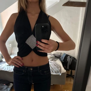 Svart croppad halterneck topp med strassdetalj - Säljer en svart halterneck topp som inte kommer till användning längre 💛