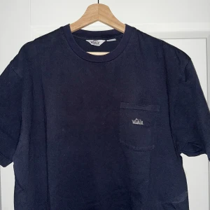 Mörkblå T-Shirt från Woolrich - Säljer en mörkblå t-shirt från Woolrich.  T-shirten är i princip ny då jag inte har använt den. Den har en bröstficka med broderad logga. Passar M men sitter något stort så nästan L. Hör av dig vid minsta fundering!