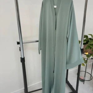 Dubai abaya sage green  - Jag säljer ut denna abaya,vi har gått ner till vårt lägsta pris, inga bud, vi har olika storlekar. Skriv för mer information och köp. 🫶🏽🤍Eftersom det är företag så är det priset som gäller och inga bud. Tack i för hand 💕Finns endast en  kvar i storleken 54, ingår chiffong hijab och bälte
