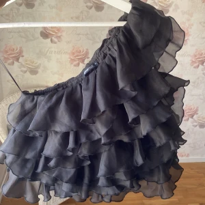 One shoulder organza topp - Köpt i oktober-november 2024 på gina tricot. Den passar rätt så tight, så hade rekommenderat den till en tjej som har en mindre bröstkorgsomfång. (Om du vill andas fritt) Den är rätt så hård i material. Men inte särskilt obekväm. (Har endast haft 2 gånger)