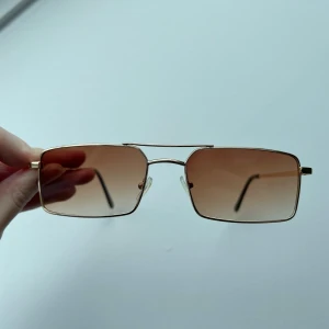 Rektangulära solglasögon med guldiga bågar - Coola solglasögon från Shein med tillhörande fodral. Liten skråma på ena linsen.