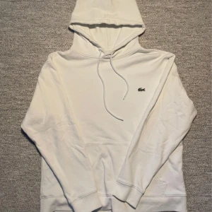 Vit hoodie från Lacoste - Säljer en klassisk vit hoodie från Lacoste, den är använt därför säljer jag för billigt.