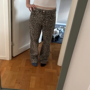 Leopardmönstrade byxor - Säljer ett par snygga leopardmönstrade byxor med normal passform och raka ben. Byxorna har knapp och dragkedja framtill och är perfekta för dig som vill sticka ut lite extra.