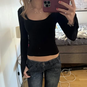 Svart långärmad topp med rund hals - Säljer en svart, tight långärmad topp med rundad halsringning. Enkel och stilren modell som sitter figurnära och passar perfekt till jeans eller kjol. Slits längst ner på armarna.