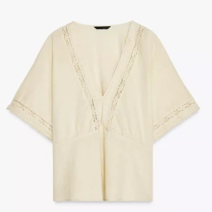 Beige blus med spetsdetaljer - Säljer en beige blus i linne material med v-ringning och fina spetsdetaljer längs halsringningen och ärmsluten från Zara. Blusen har vida, korta ärmar och en avslappnad passform. Perfekt för vår och sommar! Endast testad❤️