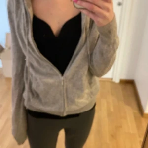 Grå hoodie med dragkedja från Soft Goat - Mysig grå hoodie från Soft Goat i mjukt material. Tröjan har dragkedja framtill, huva och fickor på sidorna. Perfekt för en avslappnad stil och enkel att matcha med det mesta. Helt okej skit men tecken för användning säljer och är även öppen för byte mot nån annan soft goat 