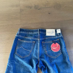 Blå jeans från Jacob Cohën - Snygga blå jeans från Jacob Cohën med klassisk femficksdesign och kontrastsömmar. Byxorna har normal passform och är tillverkade i ett mjukt denimtyg. Perfekta för dig som gillar stilrena och tidlösa jeans med exklusiv känsla.