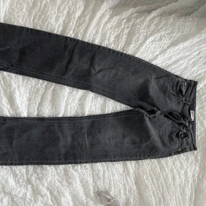 Svarta jeansbyxor från Zara - Säljer ett par svarta jeansbyxor från Zara med klassisk femficksdesign och dragkedja. Byxorna har en rak passform med slits nedtill och är tillverkade i ett mjukt denimtyg. Perfekta till många olika outfits.