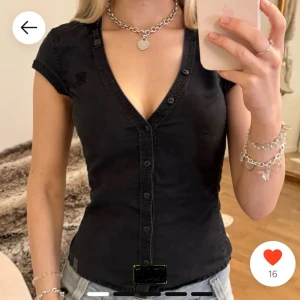 Svart kortärmad blus med knappar - Snygg svart blus från G-Star RAW med korta ärmar och knappar framtill. Den har en v-ringning och ett bälte i midjan för en smickrande passform. Perfekt för en stilren look. Lånade bilder och säljer vidare eftersom den tyvärr inte passade mig