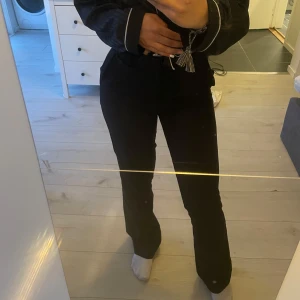 Svarta kostymbyxor med raka ben - Säljer ett par svarta kostymbyxor med normal passform och raka ben. Byxorna har hög midja och klassisk look, perfekta till en snygg outfit. Stängs med dragkedja och knapp framtill.