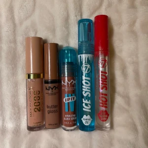 Läppglans - Fem läppglans i olika nyanser och finish. Inkluderar Max Factor 2000 Calorie, NYX Butter Gloss, NYX Hydrating Gloss Serum, W7 Ice Shot och W7 Hot Shot. Färgerna varierar från nude till transparent och blå, med både glansig och plumping effekt. 30kr/st